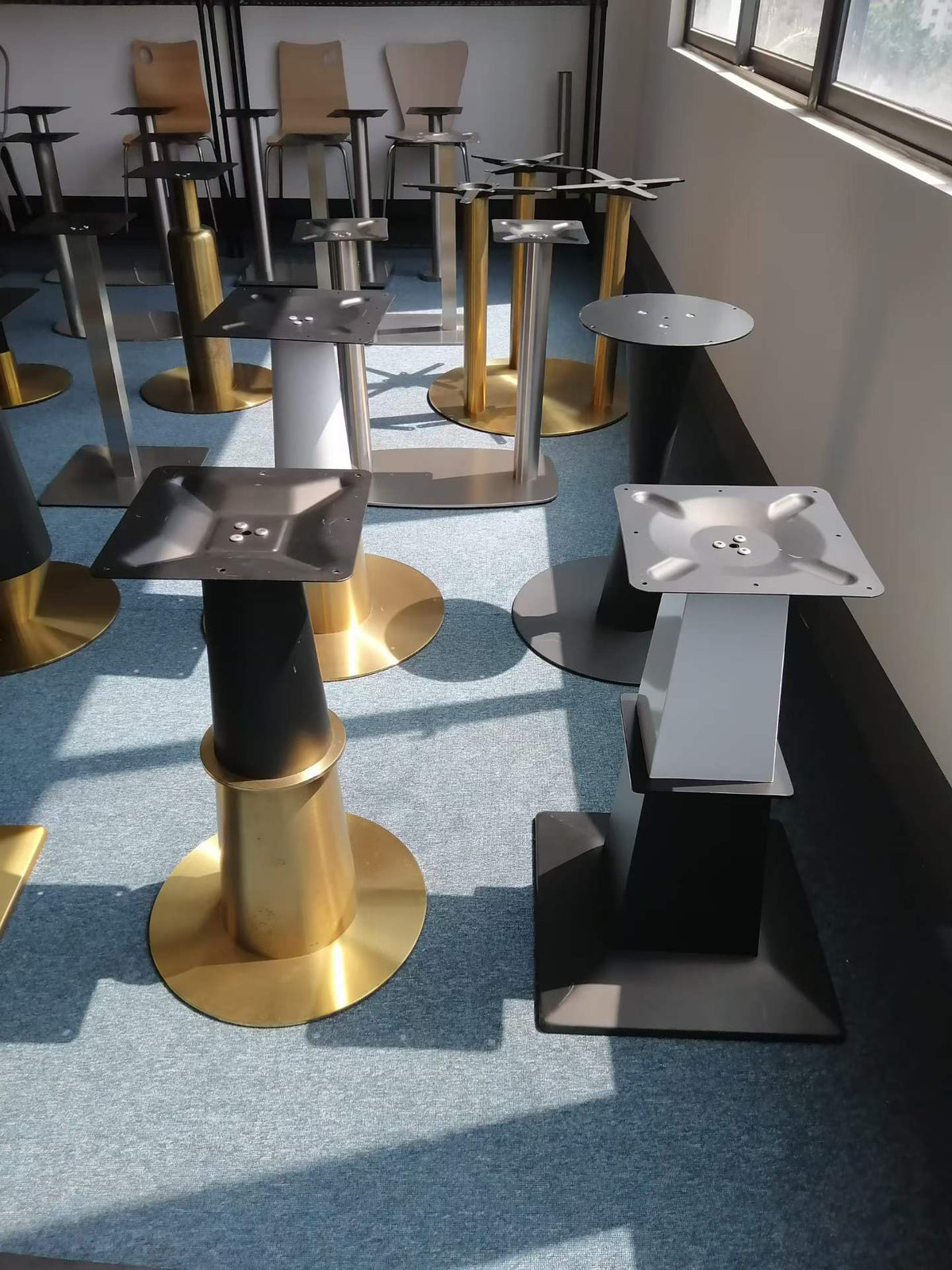 Table bases in black and gold finishes displayed in showroom