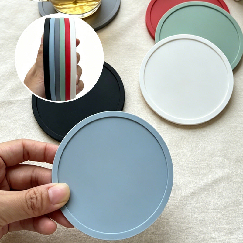 Round soft rubber coasters in neutral tones styled on a cafe table with drinks