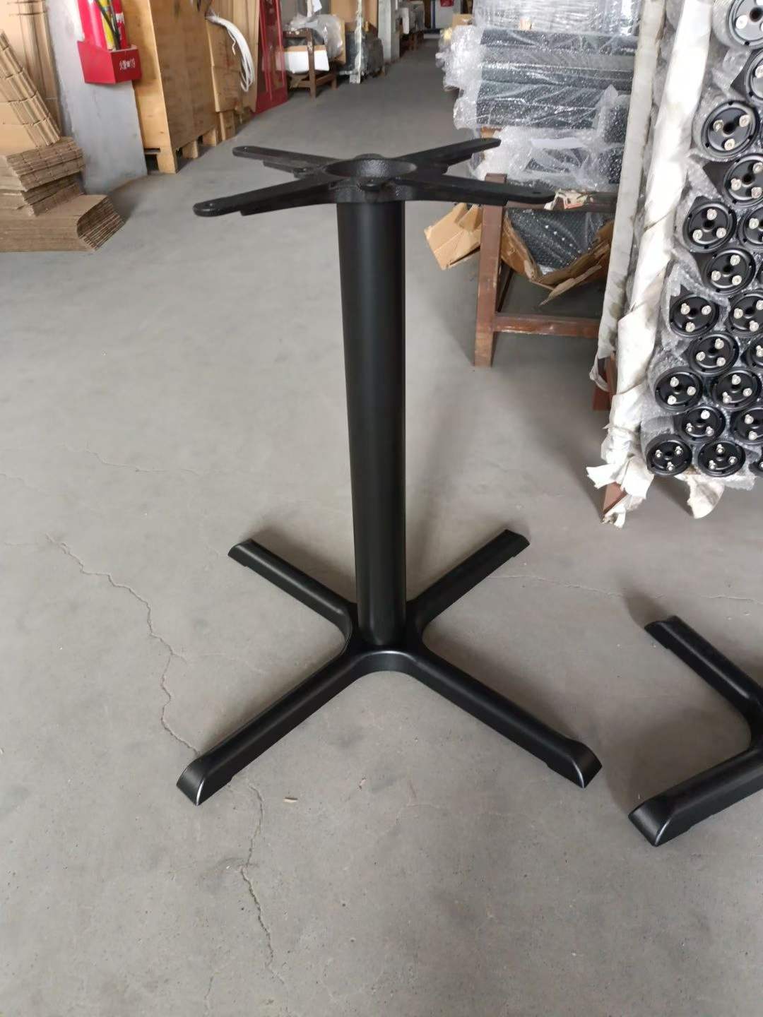 Black metal single-column table base with square-tube X-legs and 4-hole mounting plate