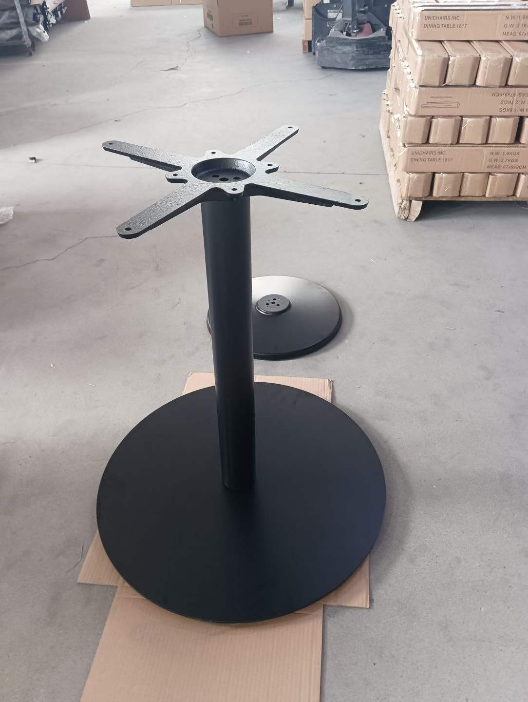 Round disc base version of the modern metal single-column table base in black
