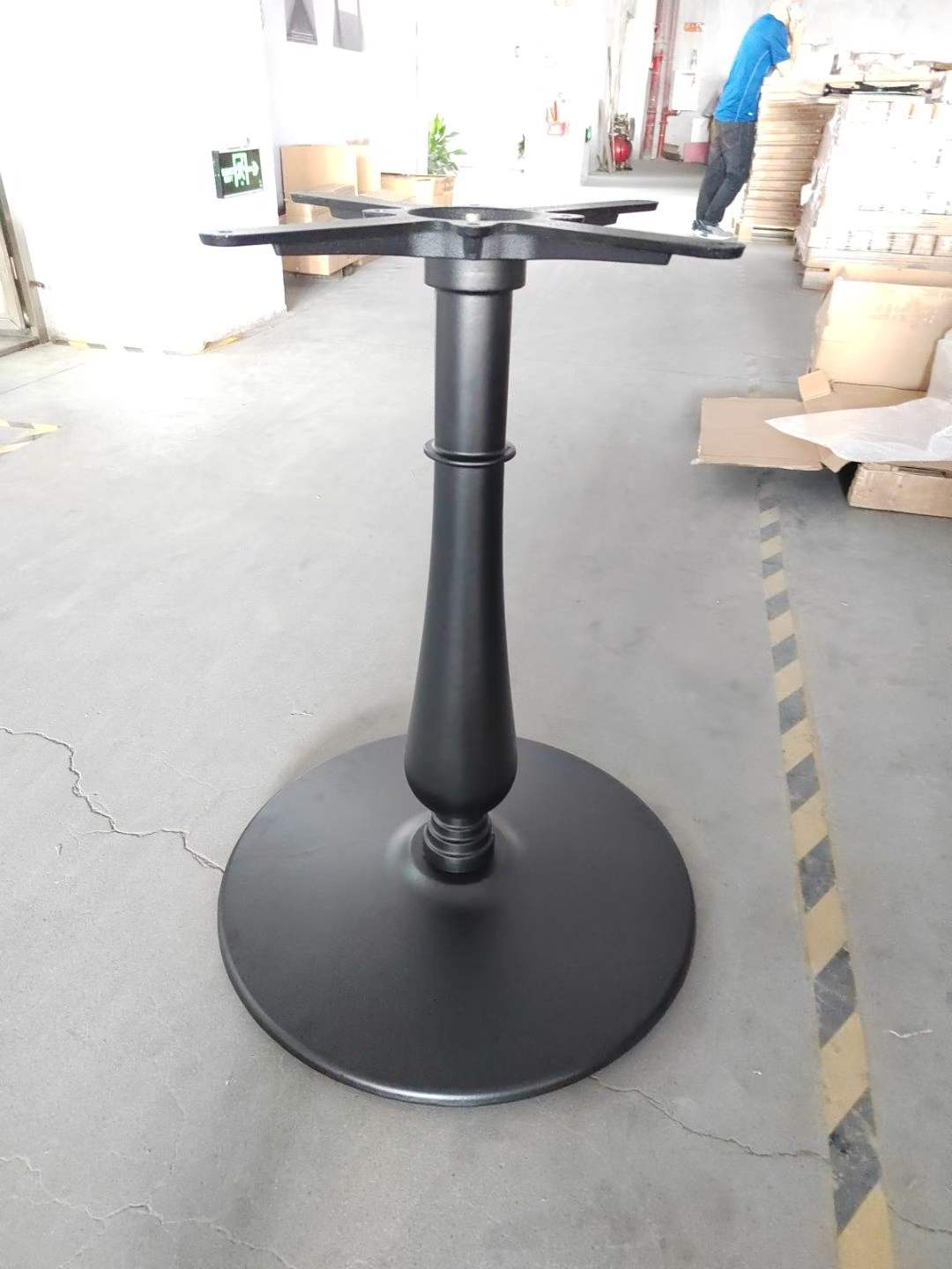 Black metal single-column table base with X-legs shown under a cafe tabletop