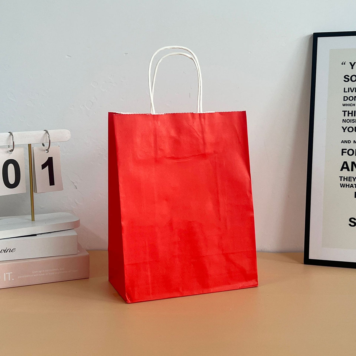 Close-up of a colored paper shopping bag showing the paper rope handle attachment