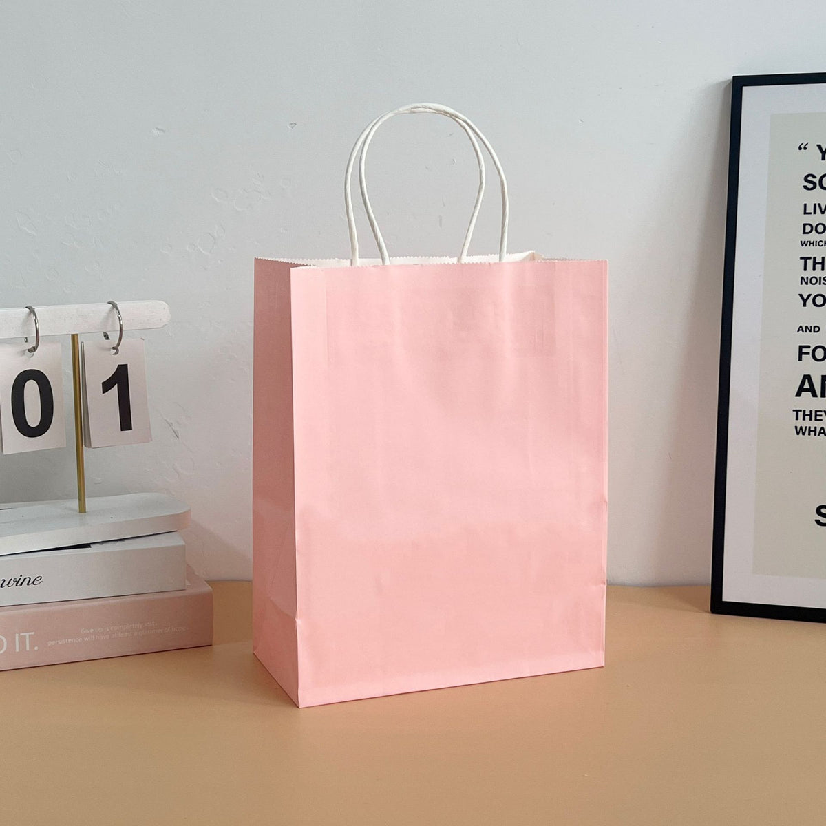 Assorted colored paper tote bags arranged in a row for retail display