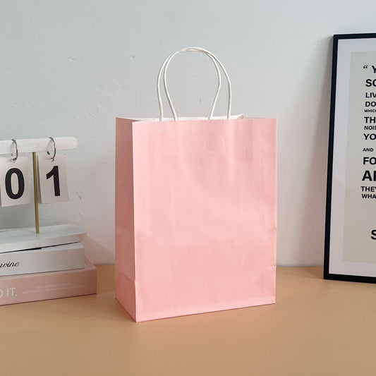 Assorted colored paper tote bags arranged in a row for retail display