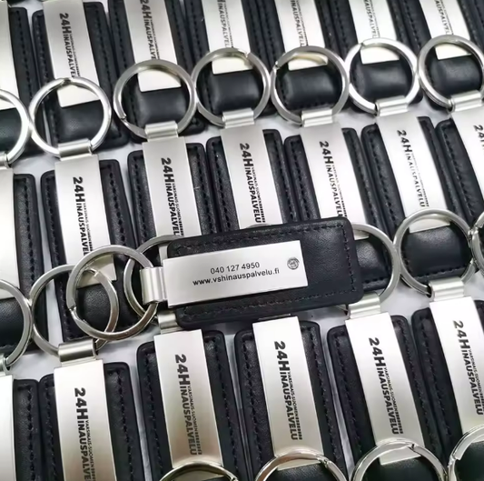 Black leather keychain with engraved metal plate showing a custom logo