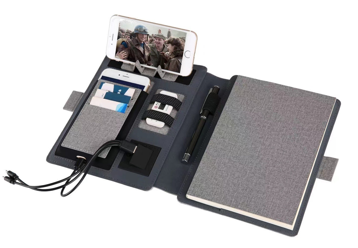 Business notebook with power bank shown next to a coffee cup on a cafe table