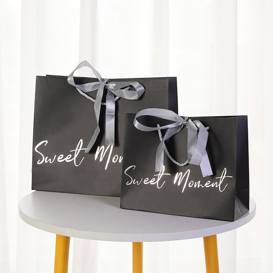 White paper gift bag with silver foil text and metal twisted rope handle for cafe packaging