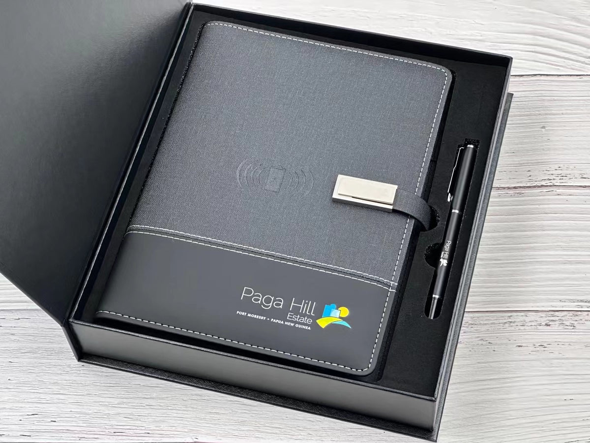 OEM branded wireless charging notebook with metal buckle on wooden desk