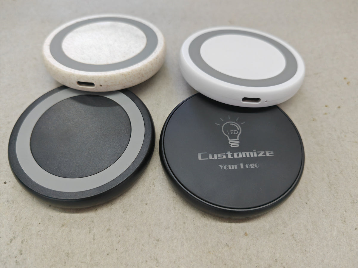 Small round wireless charger in black shown at an angle on a white background