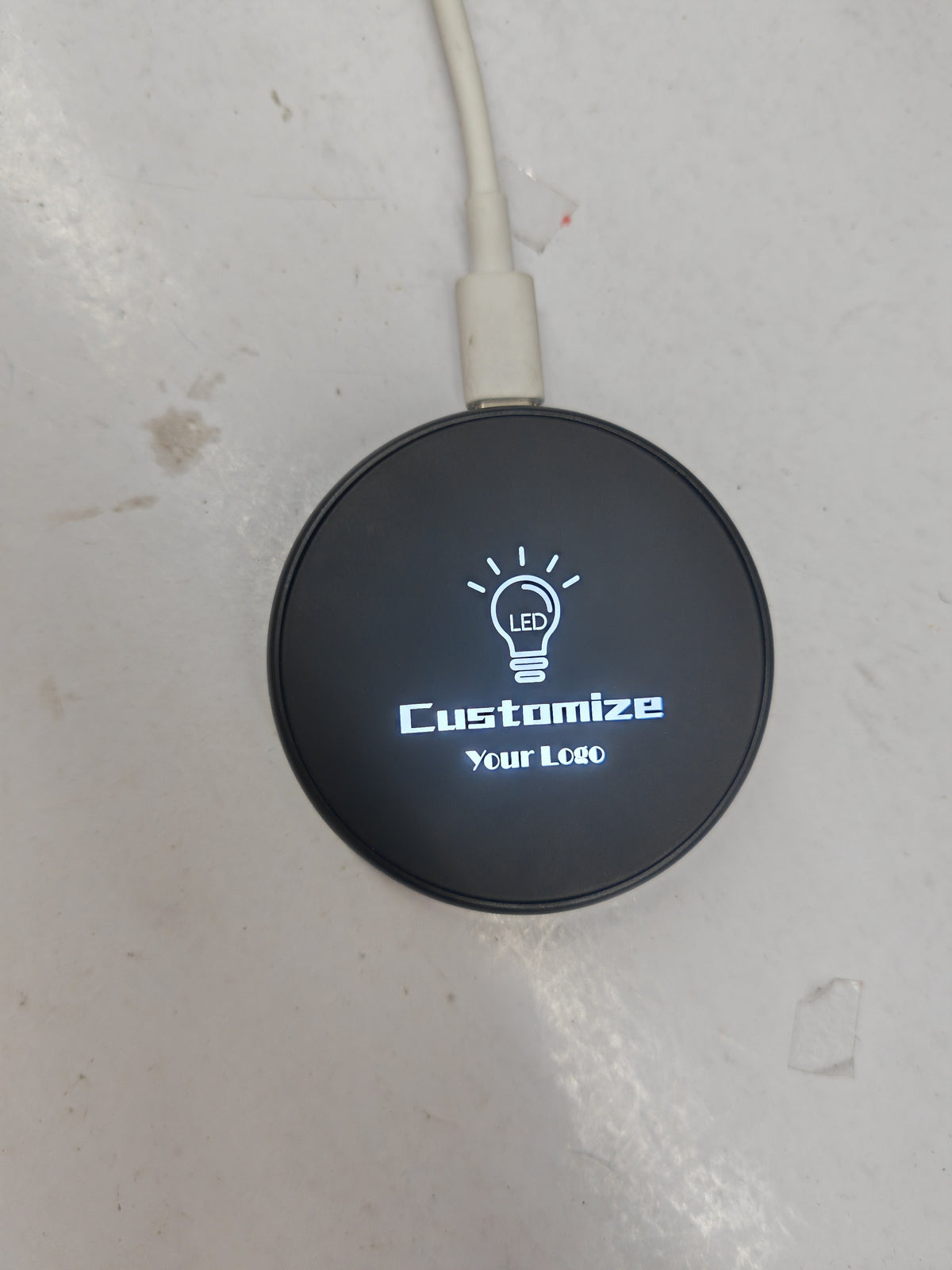 Top-down view of the 65mm round wireless charger with a clean matte surface