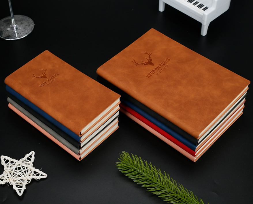 Close-up of the embossed deer-head emblem on a tan leather notebook cover