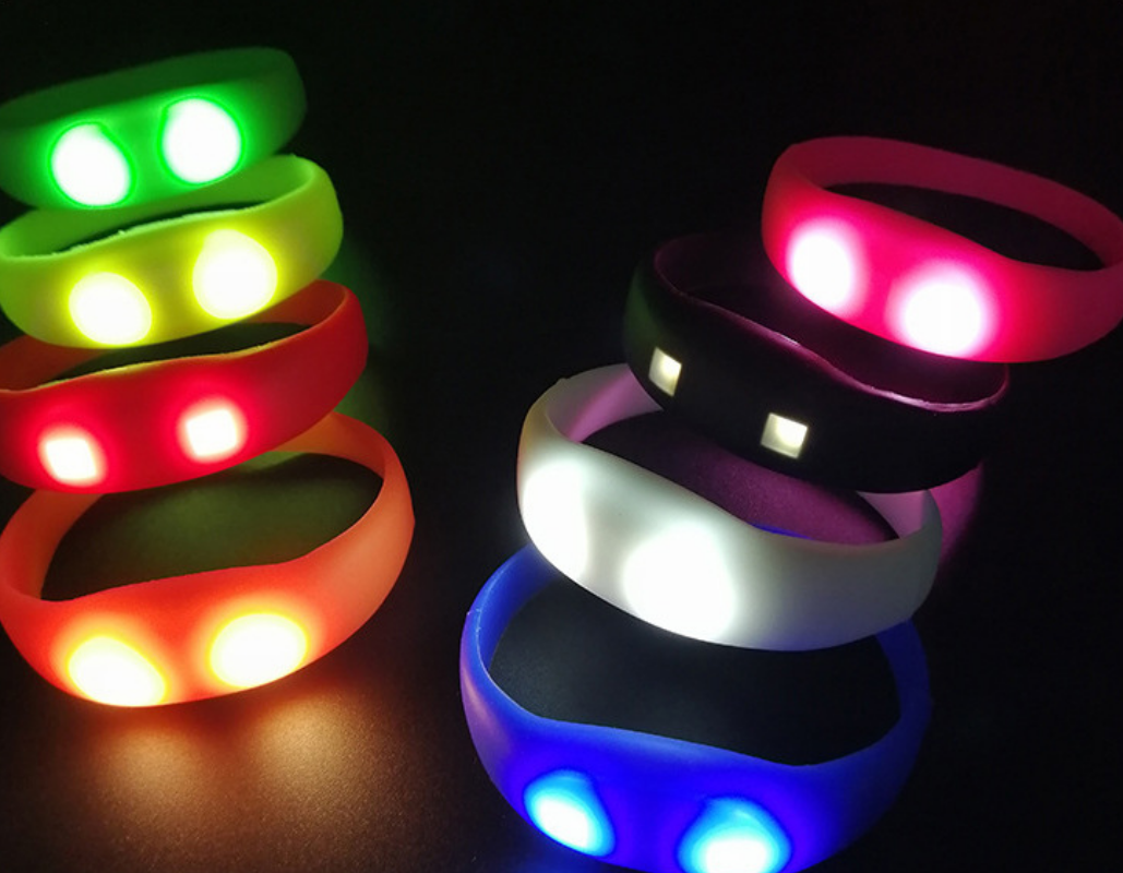 Assorted LED silicone glow wristbands in five colors arranged in a row