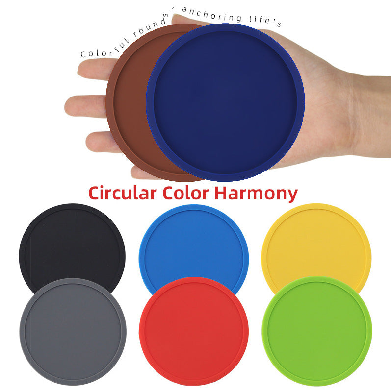 Stack of round soft rubber coasters in multiple colors on a wooden table