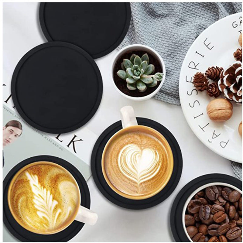 Round custom logo rubber coaster with printed branding beside a coffee cup
